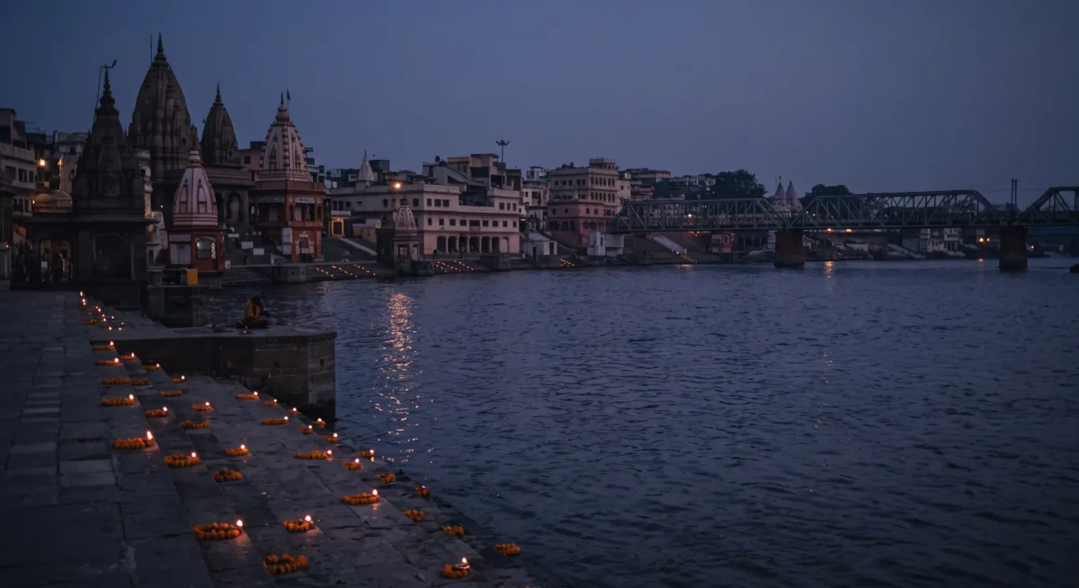 Oil lamps lit along a riverside temple ghat at dusk